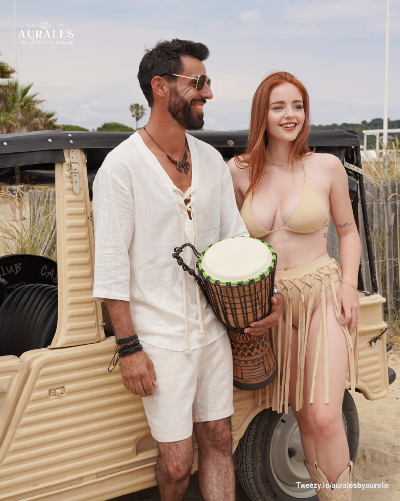 <p>Capturing the carefree spirit of summer, this duo embodies style with earthy tones and natural textures. He is dressed in a light linen tunic with rustic rope detailing, complemented by relaxed shorts that offer comfort and class for any summer day. She stuns in a neutral bikini paired with a fringe skirt that adds movement and flair, perfect for dancing by the beach or enjoying sun-filled adventures. Together, they radiate <strong>bohemian charm</strong>, ready <strong>for endless summer moments</strong> full of music, rhythm and laughter.</p>